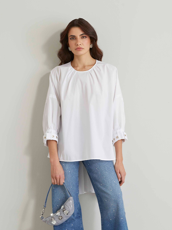 Modella indossa blusa di colore bianco.
